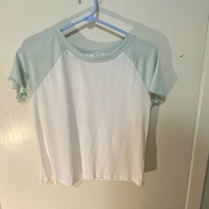 A Hippie Rose t-shirt with teal colored sleeves.